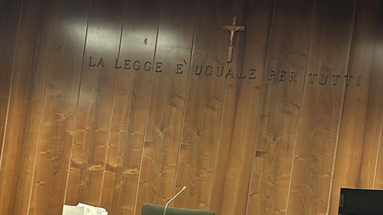 Aula di tribunale con la scritta La legge e uguale per tutti